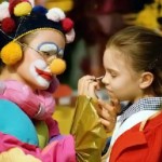 Clown putting make-up on a girl